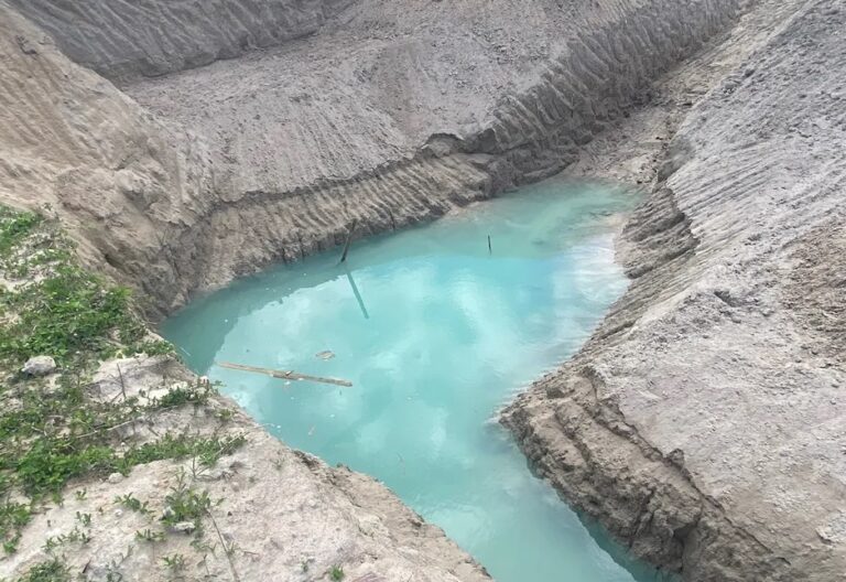 Imagem aérea do lago azul formado durante escavação.