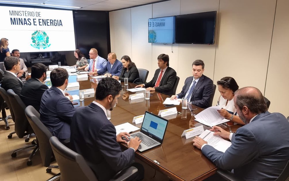 Imagem da sala de reunião no Ministério de Minas e Energia com participantes sentados à mesa.