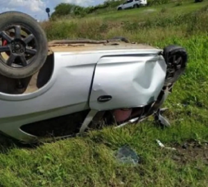 Imagem do carro destruído e capotado.