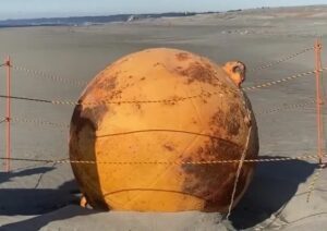 Imagem da esfera gigante na beira da praia.