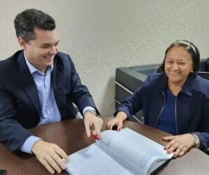 Imagem da governadora Fátima Bezerra sentada à mesa com vice-governadora Walter Alves na transmissão do cargo.