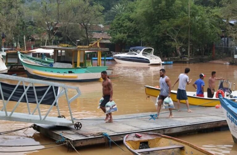 Imagem de homens carregando donativos no trabalho do socorro às vitimas da tragédia.