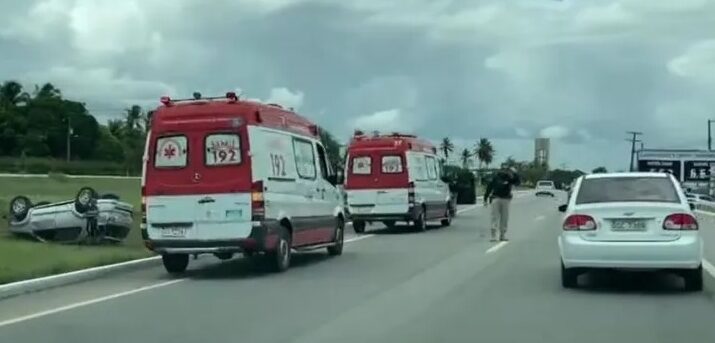 Imagem do carro capotado no canteiro central e as viaturas do Samu na pista.