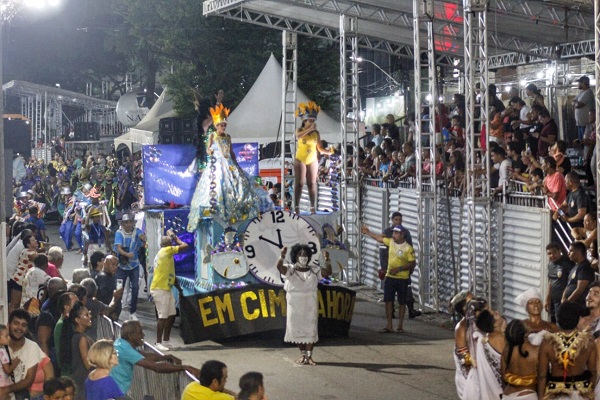 Imagem do desfile das escolas de samba de Natal com arquibancadas lotadas.