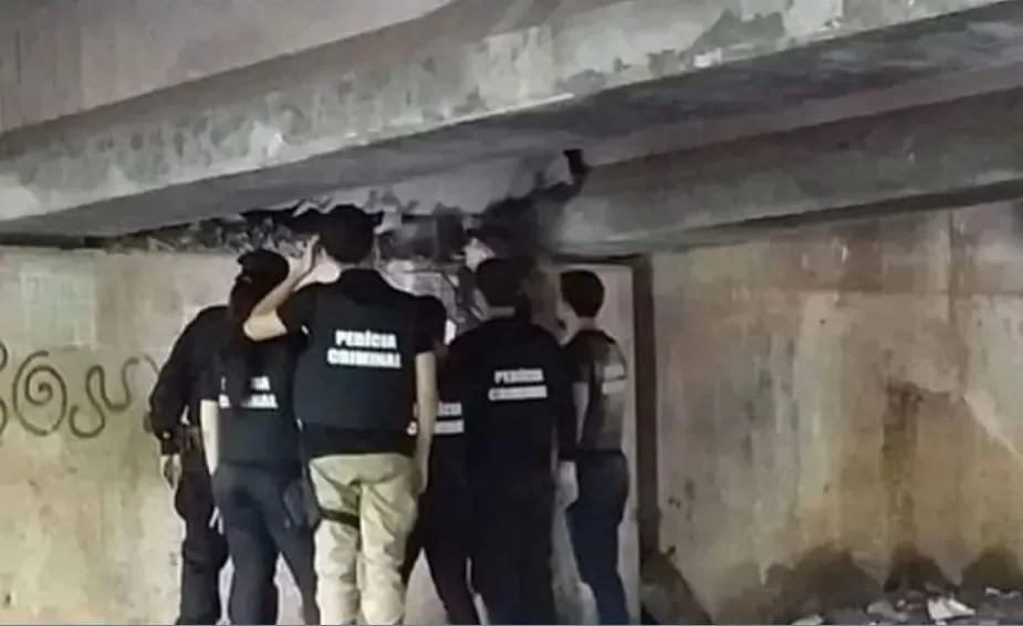 Técnicos realizando a perícia na área inferior da ponte para avaliar os estragos dos explosivos.