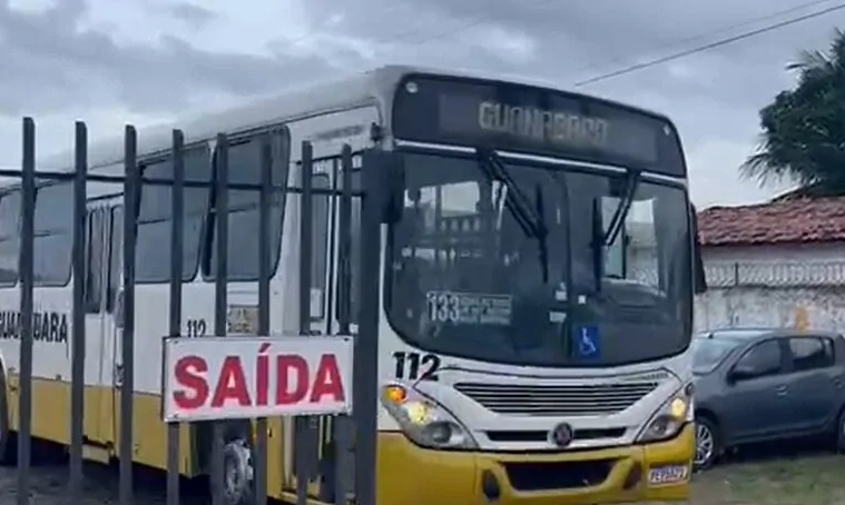 Imagem de ônibus saindo da garagem da empresa.