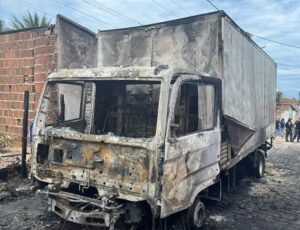 Caminhão baú incendiado e totalmente destruído.