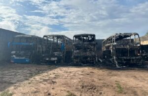 Imagem de ônibus de turismo incendiados no pátio da empresa.