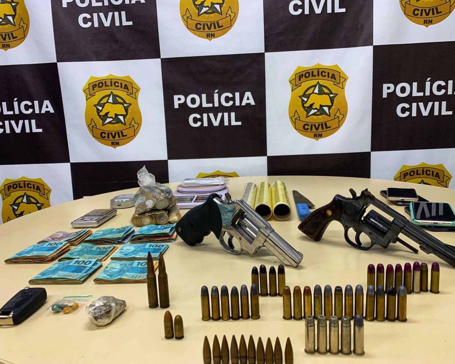 Imagem do dinheiro, armas, munição e outros materiais apreendidos.